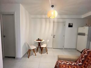 een woonkamer met een tafel en een koelkast bij Apartamento de 2 quartos, com piscina e há 10 km de copacabana in Rio de Janeiro