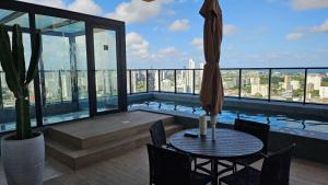a balcony with a table and a swimming pool on a building at Loft Alto Padrão Um Quarto in Recife