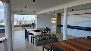a restaurant with tables and benches and a balcony at Loft Alto Padrão Um Quarto in Recife +35 photos