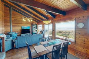 a dining room with a table and a couch at Rockaway Beach Cozy Cabin in Rockaway Beach