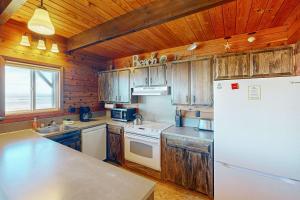 ロックアウェイ・ビーチにあるRockaway Beach Cozy Cabinの木製のキャビネットと白い冷蔵庫を備えたキッチン +19枚の写真