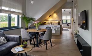 a living room with a couch and a table and chairs at Apartamenty Winnica Milsko in Milsko