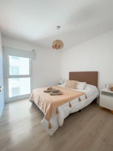 ein weißes Schlafzimmer mit einem großen Bett und einem Fenster in der Unterkunft Departamento Rivadavia Centro in Santa Rosa