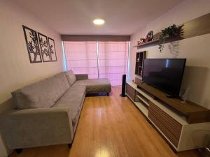 a living room with a couch and a flat screen tv at Hermoso departamento totalmente amoblado - Lte San Miguel in Lima
