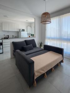 ein Wohnzimmer mit Couch und Küche in der Unterkunft Departamento Rivadavia Centro in Santa Rosa + 9 Fotos