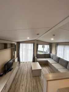 a living room with a couch and a tv at 34 Brean Leisure Park Unity Beach 6 berth Passes optional No pets in Brean