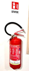 a red fire extinguisher is attached to a wall at Top Apartment 2 in Castel d'Azzano