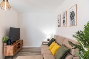 a living room with a couch and a flat screen tv at Apartamento Verde Atlântico in Ponta Delgada