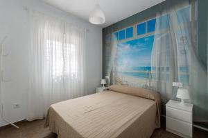 a bedroom with a bed and a painting of the ocean at Casa Moisés Brisa in Cádiz +23 photos