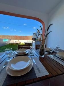 a wooden table with plates and wine glasses on it at Casa Moisés Brisa in Cádiz