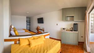 Una pequeña habitación con dos camas y una cocina. en Monaco Apartments Chicama, en Puerto Chicama