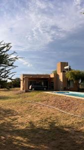 une maison avec une voiture garée devant dans l'établissement Casa Las Breas del Champaquí, à Las Tapias