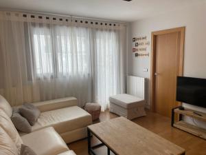 a living room with a couch and a television at Apartamento Villanua centro in Villanúa