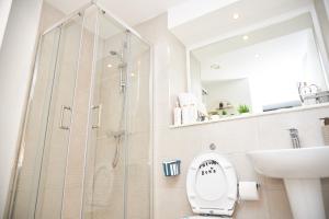 Un baño con ducha, inodoro y lavabo. en OBI'S House&Suites - Luxury 2bed Duplex Apartment With Balcony, en Mánchester