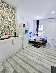 a small room with a bed and a refrigerator at Apartamento Metro Manises y Aeropuerto in Manises