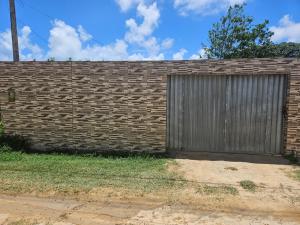 a brick wall with a door and a garage at Casa de praia 1 in Goiana