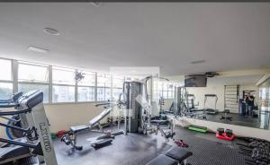 ベロオリゾンテにあるRaja Flatの複数のトレッドマシンと人々が背景に存在するジム