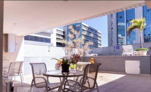 ベロオリゾンテにあるRaja Flatのバルコニーにテーブルと椅子が置かれたパティオ