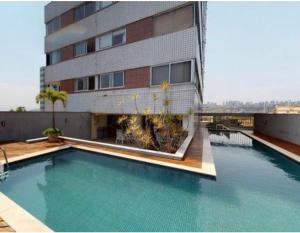 ベロオリゾンテにあるRaja Flatの建物の前にプールがある建物