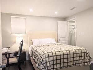 a bedroom with a bed with a checkered blanket at Kings Palace Basement in Brampton