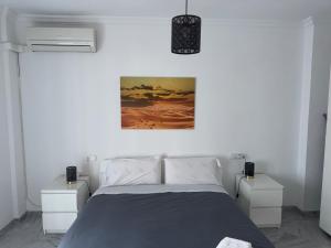 a bedroom with a bed and two night stands at Encanto Urbano: Piso céntrico totalmente equipado in Lebrija