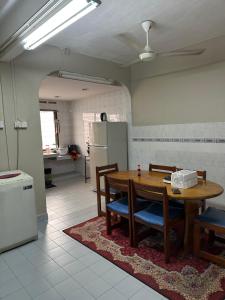 テメルローにあるNADDY HOMESTAY Temerloh Jayaのテーブルと椅子のあるキッチンとダイニングルーム +10枚の写真