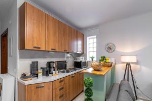 a kitchen with wooden cabinets and a couch at Philoxenia Kozani in Kozani +23 photos