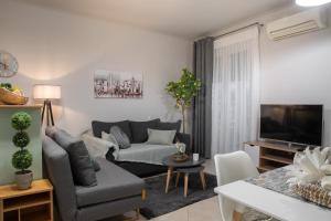 a living room with a couch and a tv at Philoxenia Kozani in Kozani