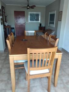 a wooden table with chairs and a dining room at Aires del Parque in Paraná +9 photos
