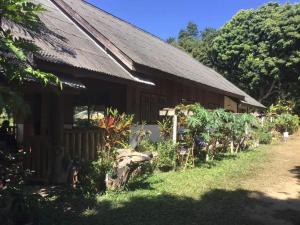 a building with a bunch of plants in front of it at Joyful Haven Home in Ban Ngiu Thao Mai