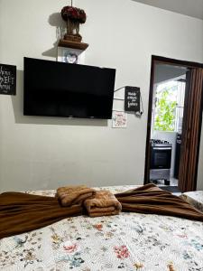 a blanket laying on top of a bed with a tv on the wall at Centro Histórico Diamantina in Diamantina