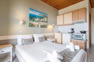 カラミツィにあるNontas Homes 31の大きな白いベッドとキッチンのある寝室