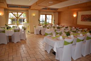 einen Bankettsaal mit weißen Tischen und Stühlen in der Unterkunft Landgasthof Hotel Rössle in Steinenkirch