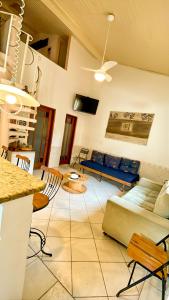 een woonkamer met een bank en een tafel bij Casa próximo da praia do Perequê com garagem, churrasqueira e ar condicionado in Ilhabela +21 foto's