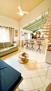 een woonkamer met een bank en een tafel bij Casa próximo da praia do Perequê com garagem, churrasqueira e ar condicionado in Ilhabela