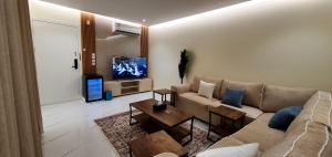 a living room with a couch and a tv at سارة للأجنحة الفندقية in Al Kharj