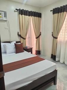 a bedroom with a large bed with curtains at JMorino Pension House in Puerto Princesa City
