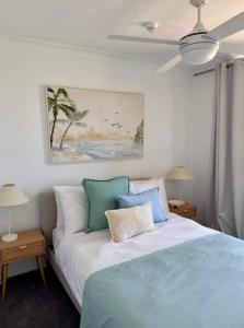 Un dormitorio con una cama azul y blanca con almohadas en Pearl By Khove, en Gold Coast 8 fotos más