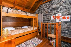 a bedroom with two bunk beds and a table and a chair at King's House - Centennial House in Ribeira do Raposo