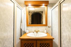 a bathroom with a sink and a mirror at King's House - Centennial House in Ribeira do Raposo