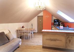 a kitchen and living room with a couch and a table at Gîte Ha-Py Cocon in Campan