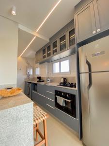 a large kitchen with a stainless steel refrigerator at Conforto e modernidade na praia 400m - mar in Porto Belo +1 photo