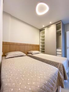 a bedroom with two beds and a mirror at Conforto e modernidade na praia 400m - mar in Porto Belo