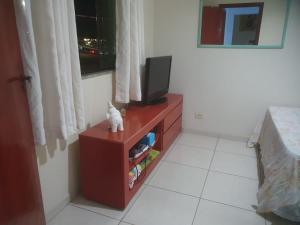 a room with a tv on a dresser with a tvictericter at quarto triplo in Caraguatatuba