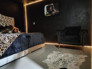 a bedroom with a bed and a chair and a rug at SUITES LIVE Toluca in Toluca