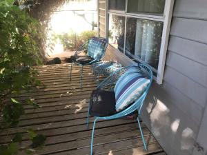 2 chaises assises sur une terrasse couverte à côté d'une fenêtre dans l'établissement Country Style Cottage, à Ouyen