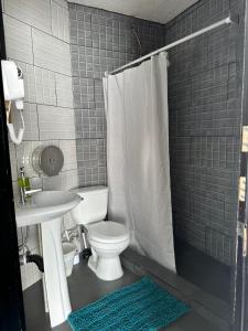 a bathroom with a white toilet and a sink at Casa Zakura in Guatemala