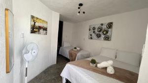 a small bedroom with a bed and a fan at Casa Zakura in Guatemala