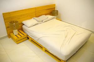 ein großes Bett mit einem Kopfteil aus Holz in einem Zimmer in der Unterkunft Villa meublee ouaga pate d'oie in Ouagadougou