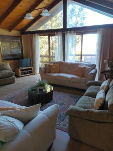 a large living room with couches and a table at Casa Lago Vichuquén, Sector Sol de la Península in Vichuquén +10 photos